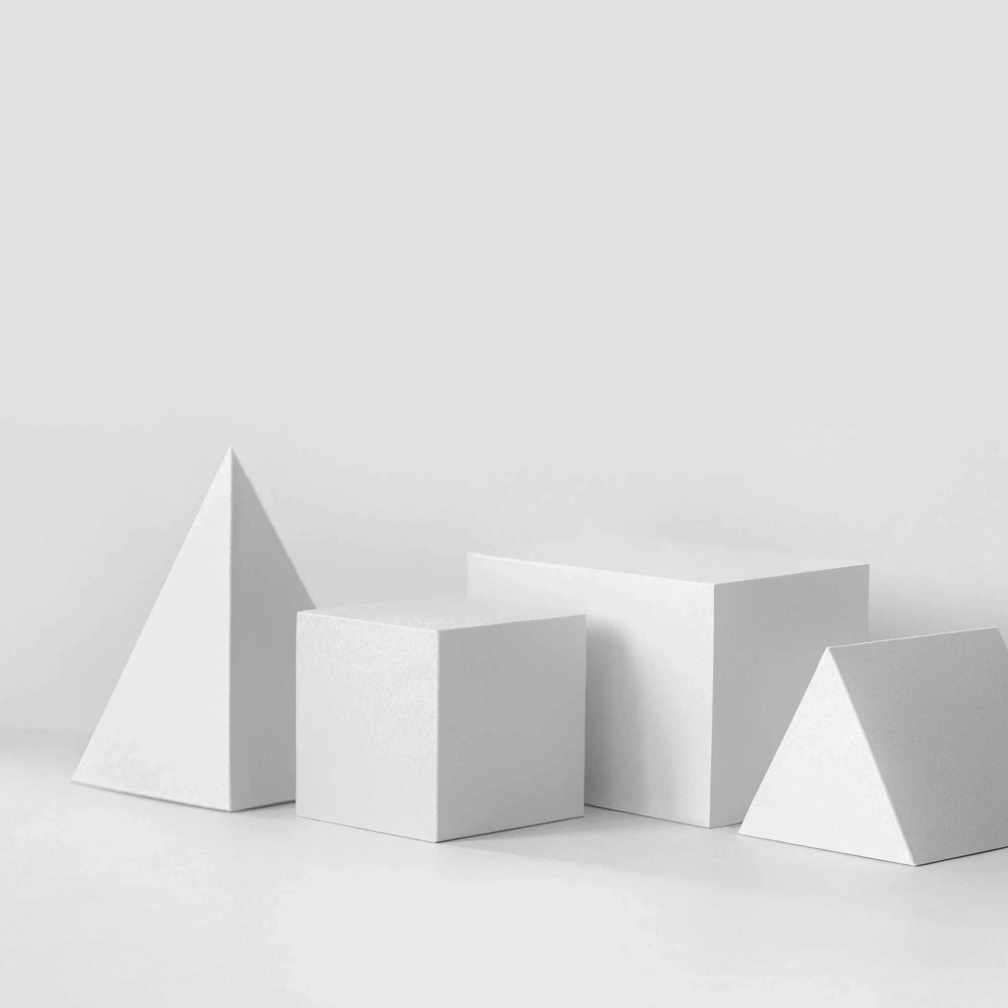 white-geometrical-figures-still-life-composition-prism-pyramid-rectangular-cube-objects-copy-space